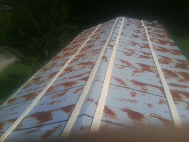 Rusted metal roof panels with new wood purlins before replacement — Storm Damage Roof Repair in Buckner by Roofing Brothers